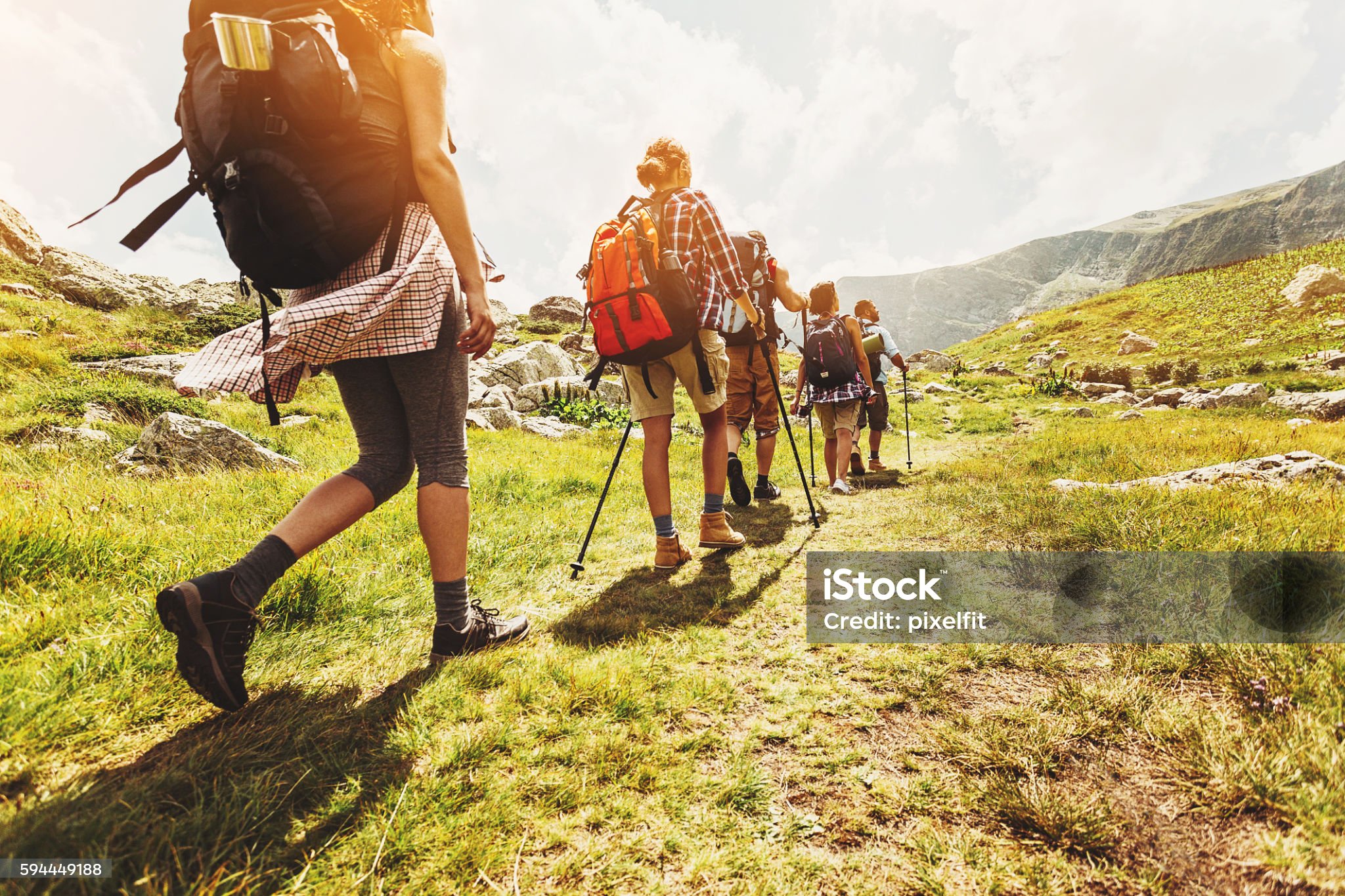 Group Of Hikers Walking In Line On A Footpath In The Mountain, With Copy Space